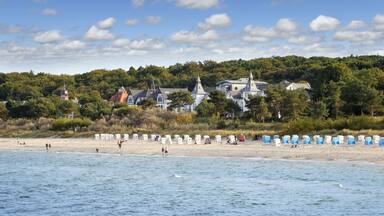 A beach with tents and a church on a hill.