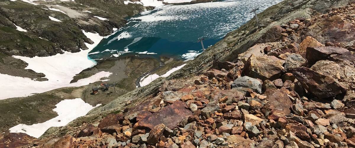 High above the mountain town of Alpe D’Huez. In summer times when the snow melts it leaves amazing blue lakes with frozen snow floating across the top.