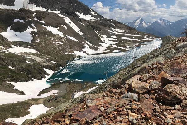 High above the mountain town of Alpe DâHuez. In summer times when the snow melts it leaves amazing blue lakes with frozen snow floating across the top.