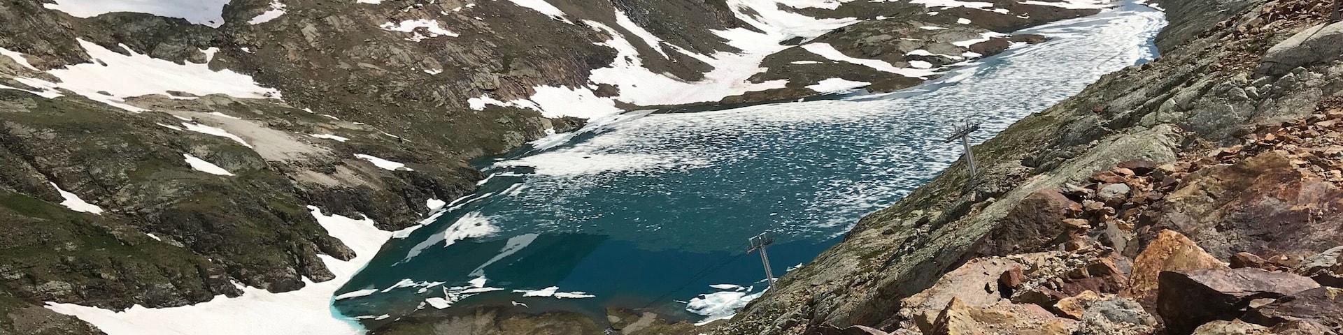 High above the mountain town of Alpe D’Huez. In summer times when the snow melts it leaves amazing blue lakes with frozen snow floating across the top.