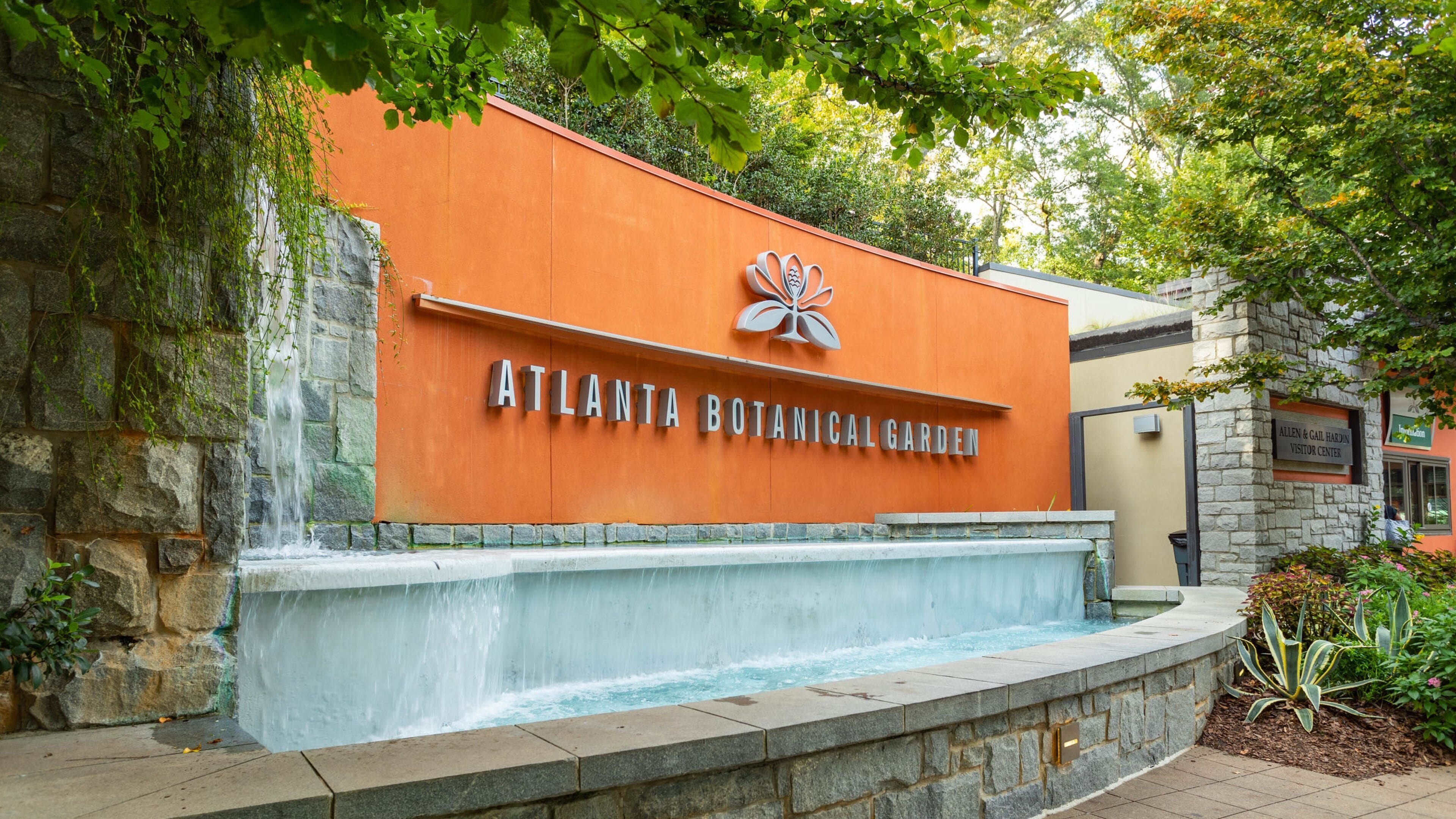 The Atlanta Botanical Garden entrance with a stone wall and a water feature.