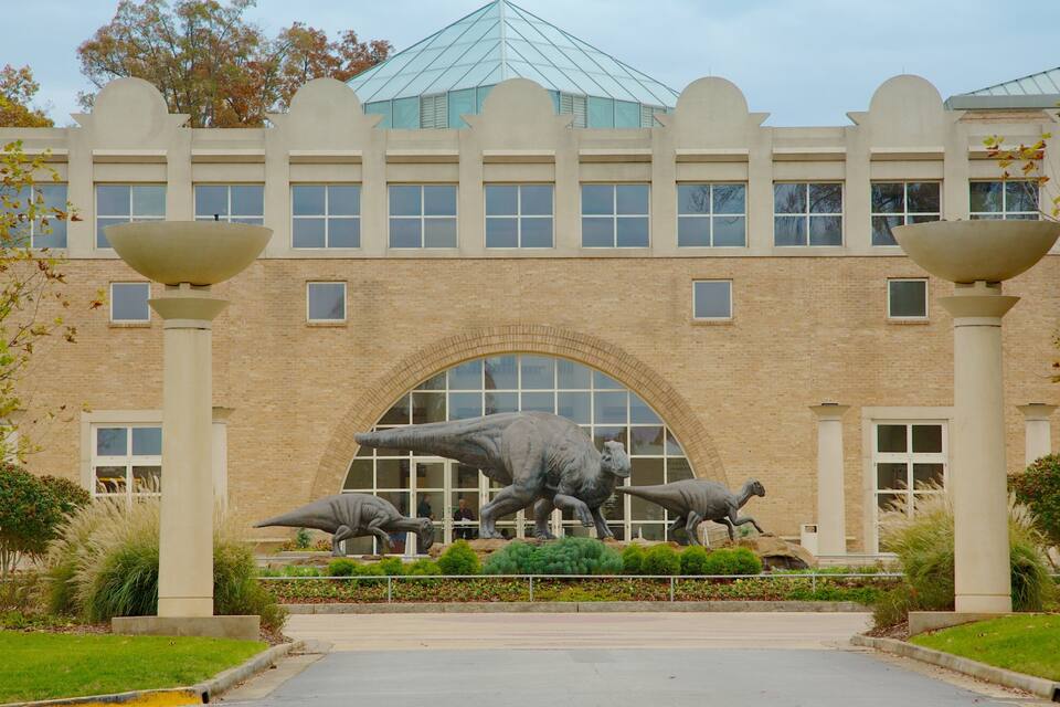 A building with a large dinosaur sculpture in front.