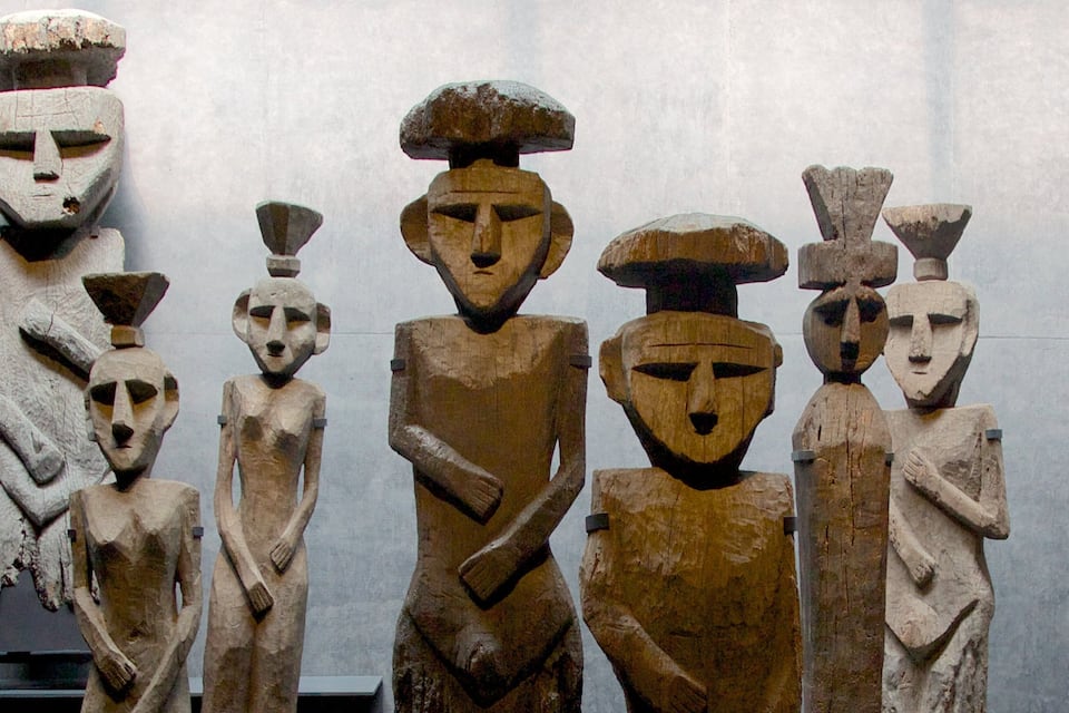 A collection of wooden sculptures with geometric shapes and faces.