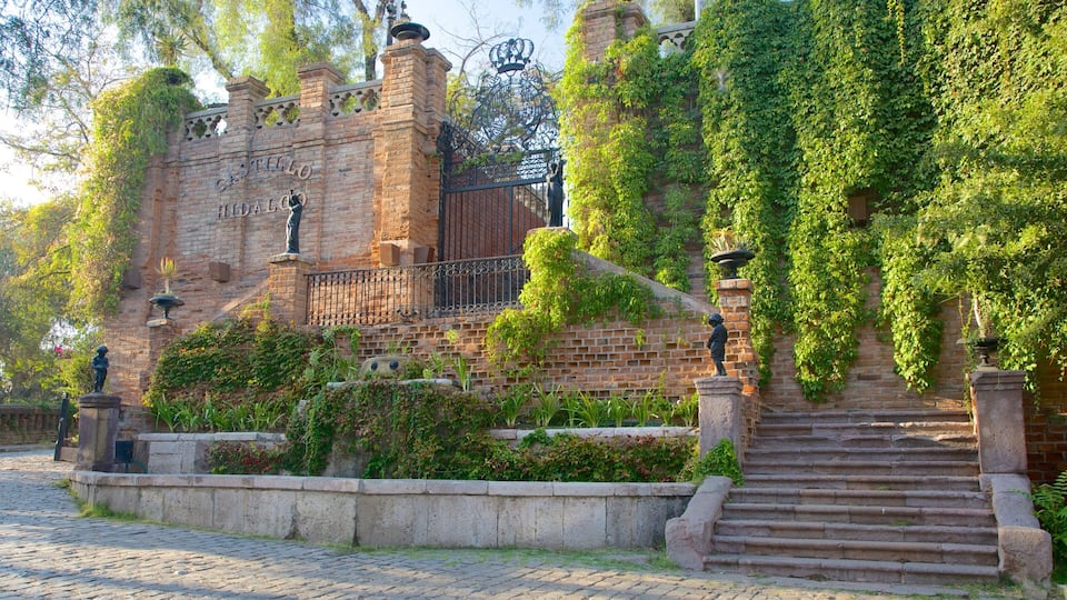 A historic brick building with ivy-covered walls and a wrought iron gate.