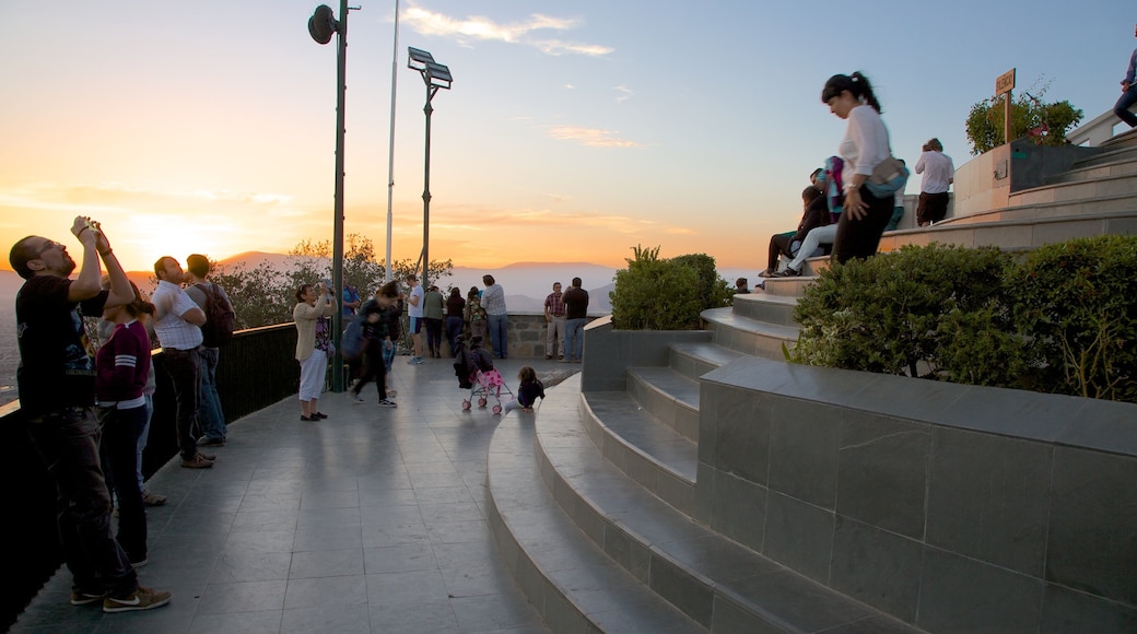 San Cristobal Hill featuring a sunset and views as well as a large group of people