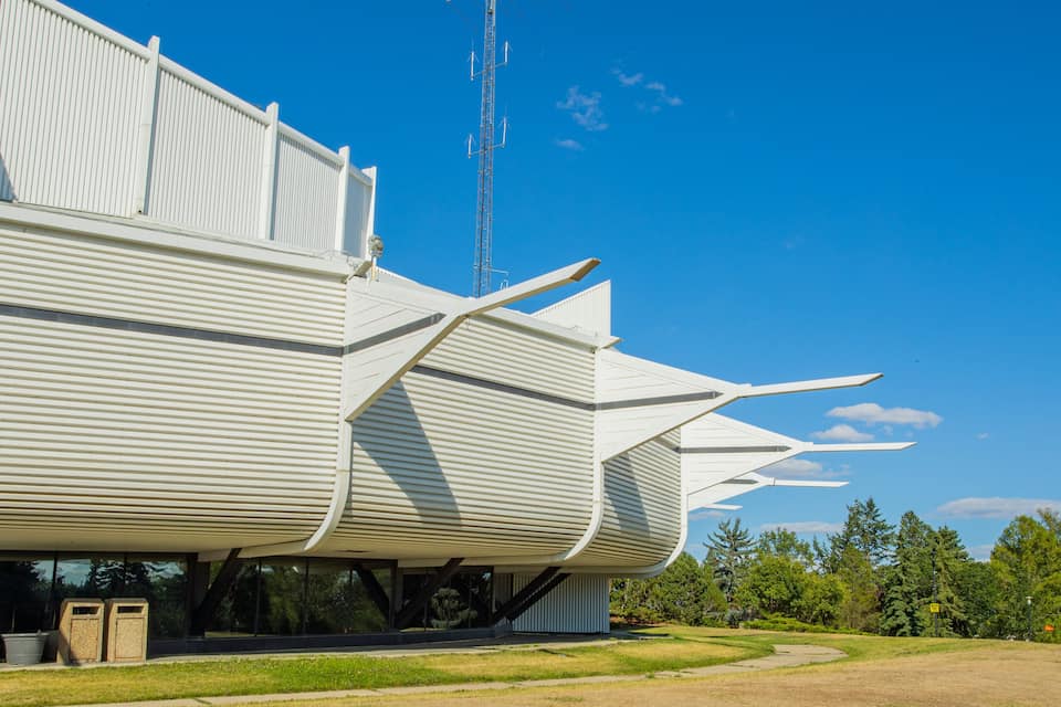 Un edifici d'arquitectura moderna amb un disseny únic, que destaca per un teulat inclinat i una gran estructura d'antena.