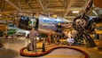 A vintage aircraft with "City of Edmonton" and "Home of the Grey Cup" text, a pilot mannequin, and a propeller.