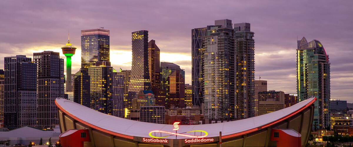 Scotiabank Saddledome which includes a city, a sunset and modern architecture