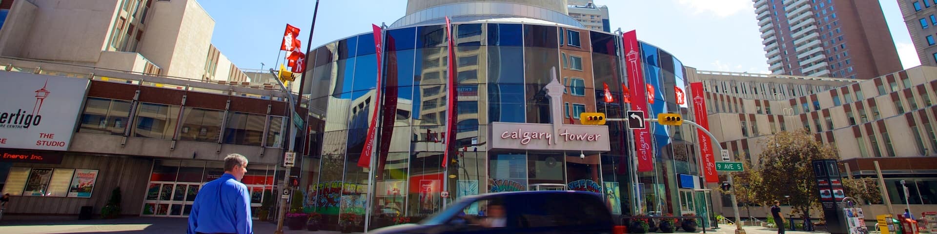 A busy urban street with a prominent tower labeled 'Calgary Tower' in the background.