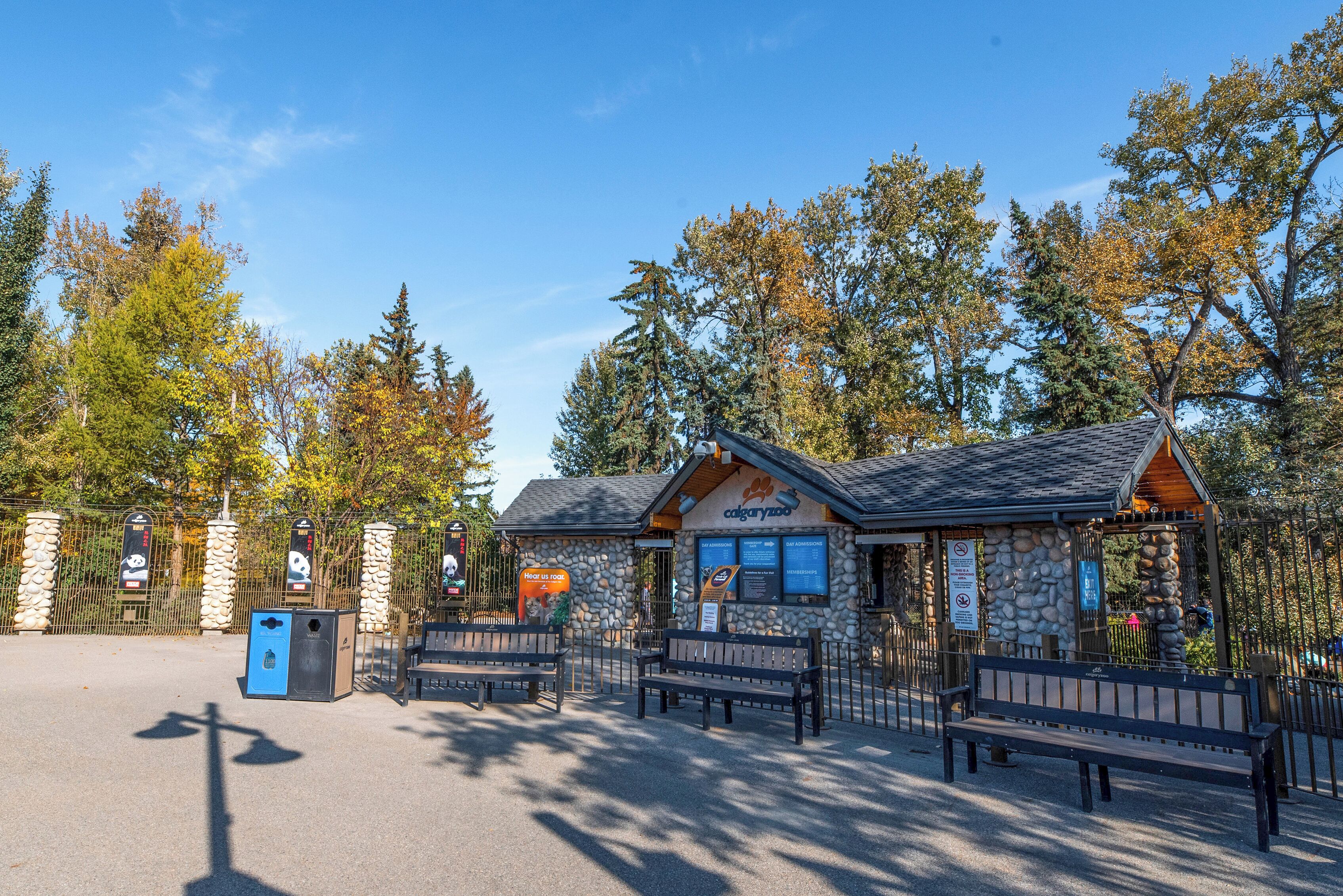 Un bâtiment en pierre sur lequel on peut lire l’inscription « Zoo de Cayuga », entouré de bancs et d’une clôture en pierre.