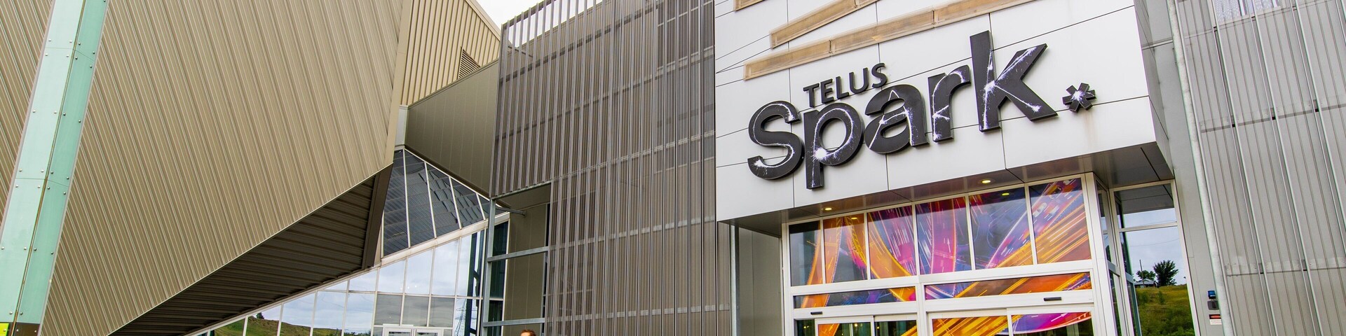 A modern building with a large sign reading "TELUS Spark."