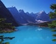 A turquoise lake surrounded by mountains and dense forest.