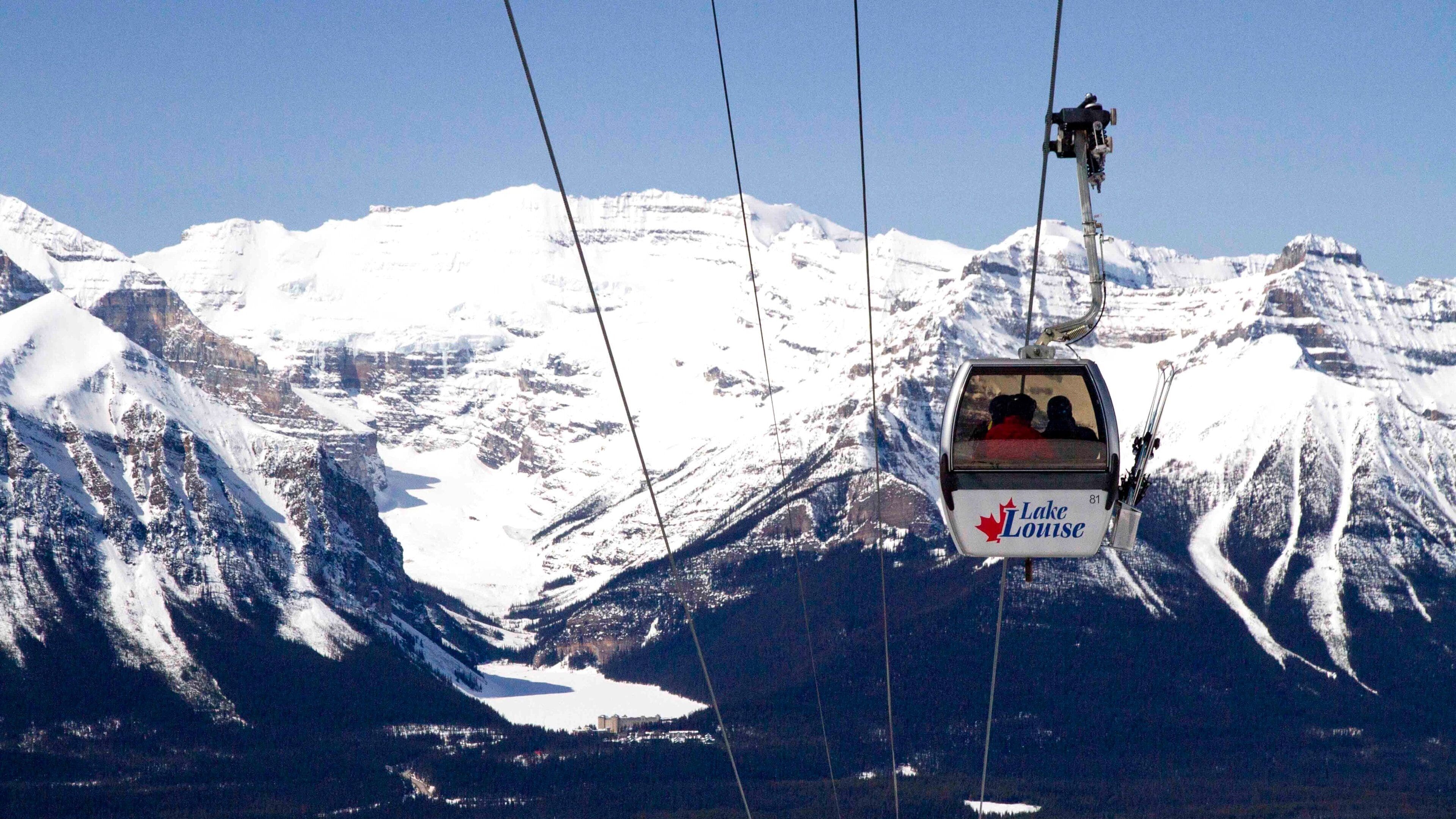Un teleférico con la leyenda 'Lake Louise' asciende un monte nevado.