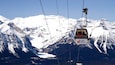 A cable car labeled "Lake Louise" ascending a snowy mountain.