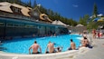 A swimming pool surrounded by stone buildings and trees.