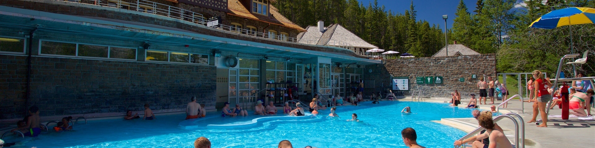 Piscina rodeada por edifícios de pedra e árvores.