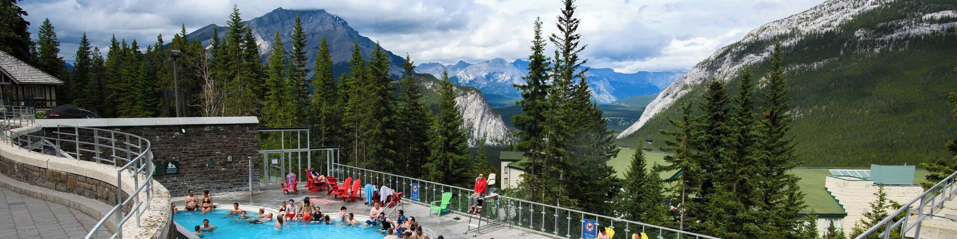 A swimming pool surrounded by mountains and trees.