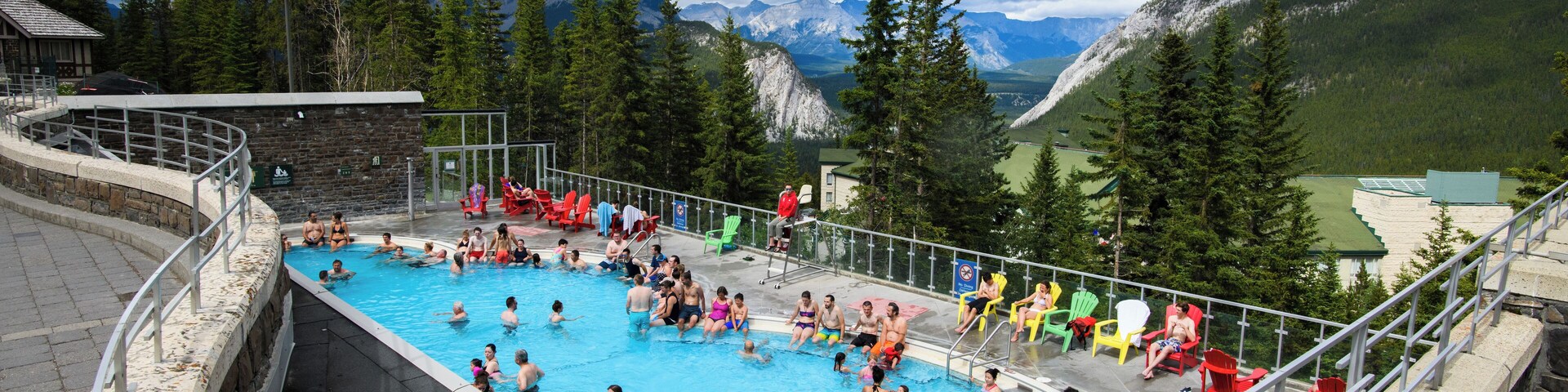 Una piscina rodeada de montañas y árboles.
