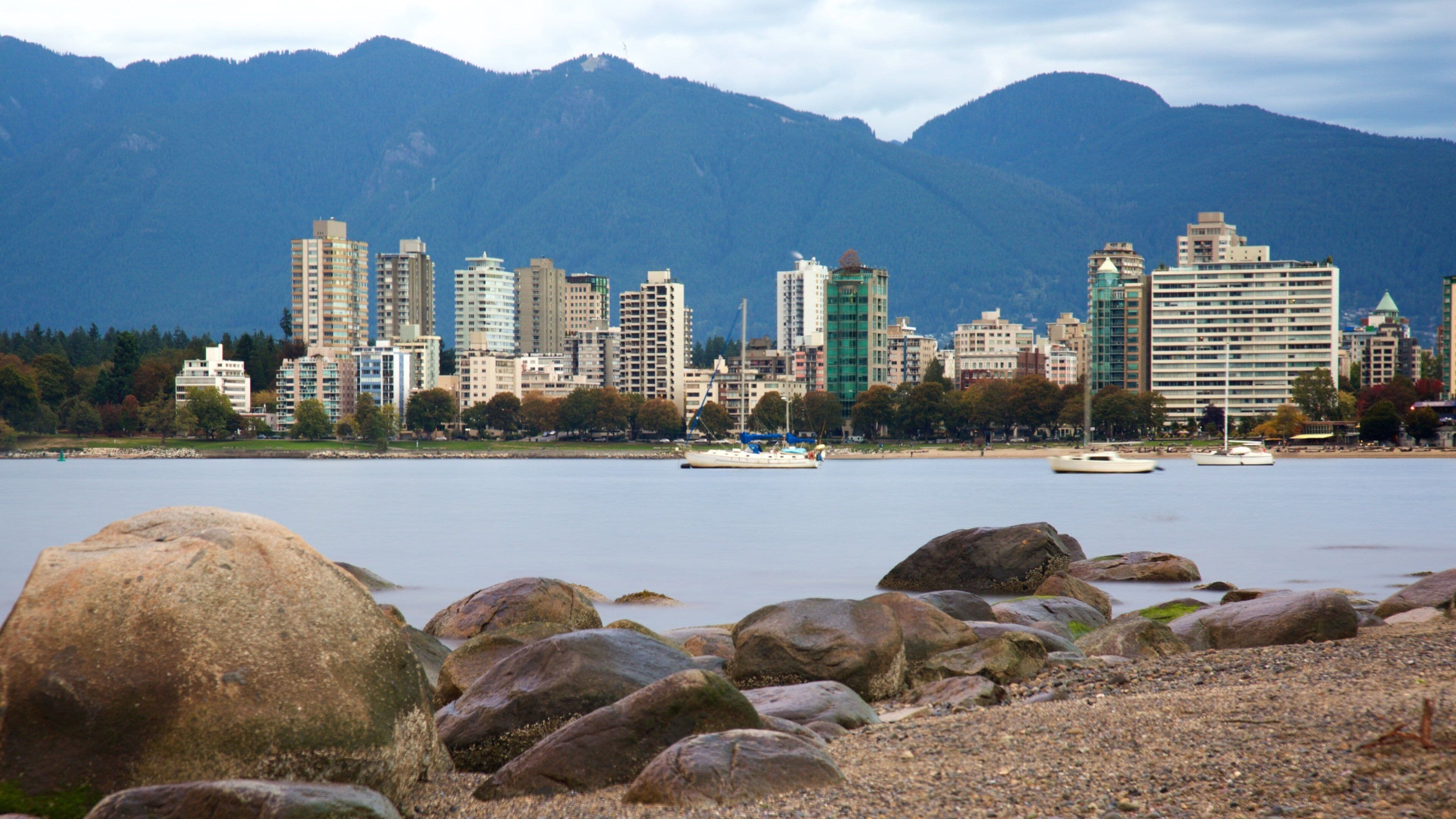 Kitsilano Beach which includes a bay or harbor, a city and mountains