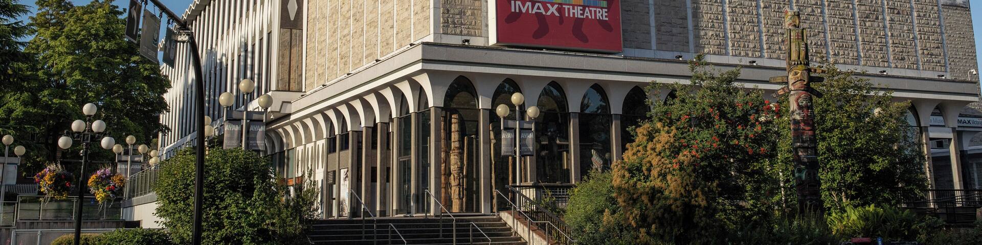 A large building with a red banner advertising the Royal BC Museum and IMAX Theatre.