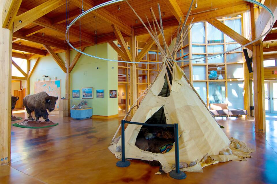 Um edifício de madeira espaçoso com teto alto e uma estrutura tipi no centro.