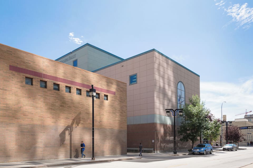 A modern building with a large glass window and a brick facade.
