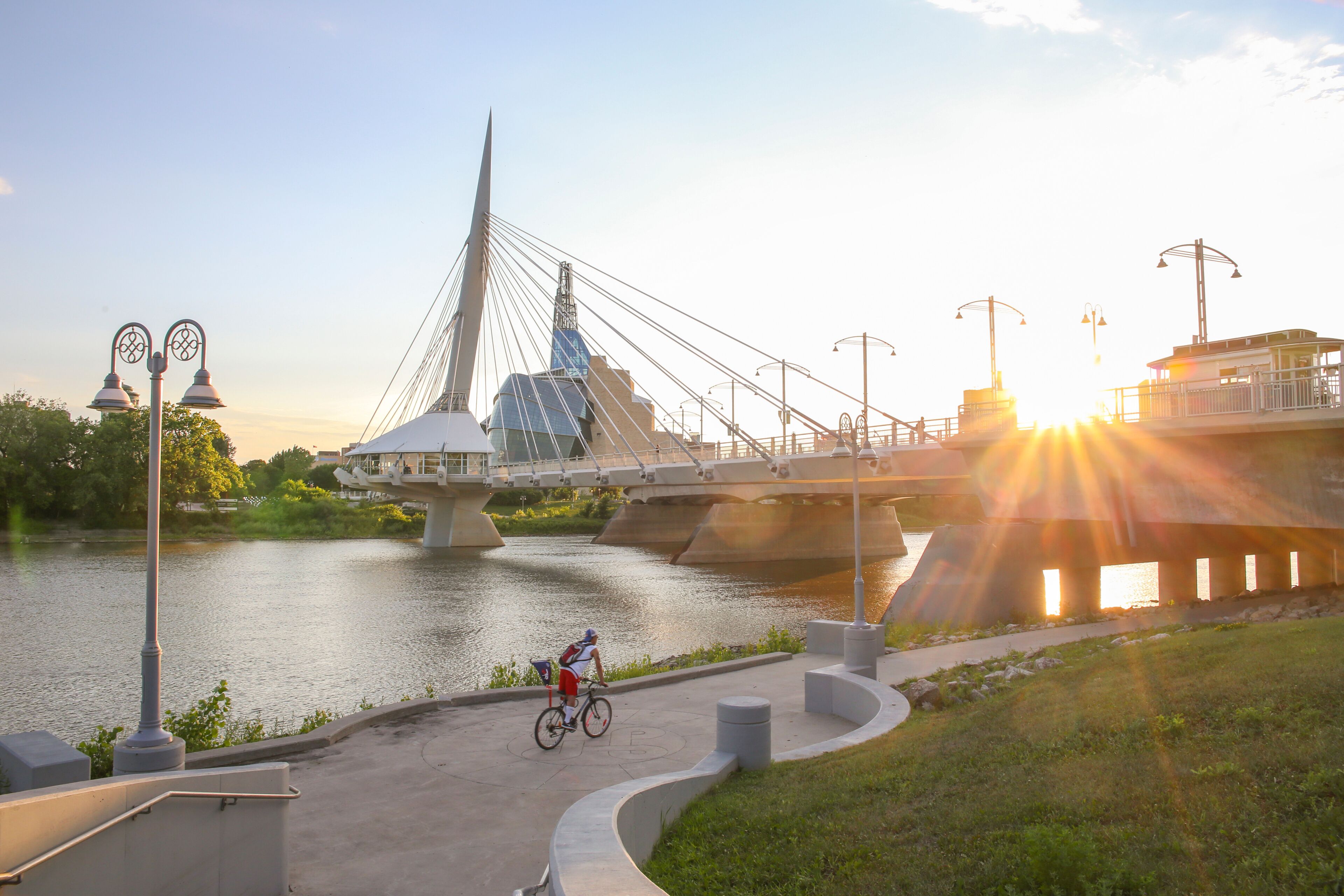 Cyclists along Red River in a sunny day. Peaceful sunset scene. Winnipeg, Canada.