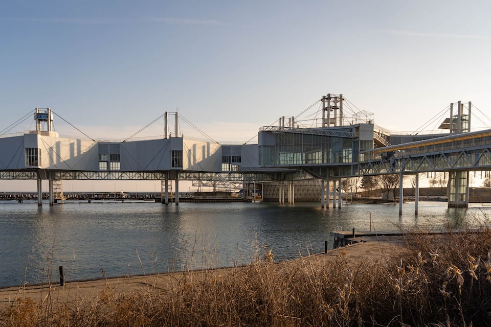 A bridge over a river with industrial buildings in the background.