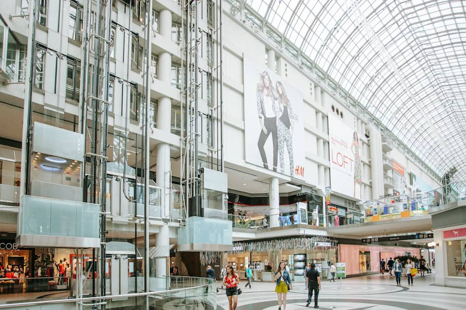 Een meerlaags winkelcentrum met hoge plafonds en glazen balustrades.
