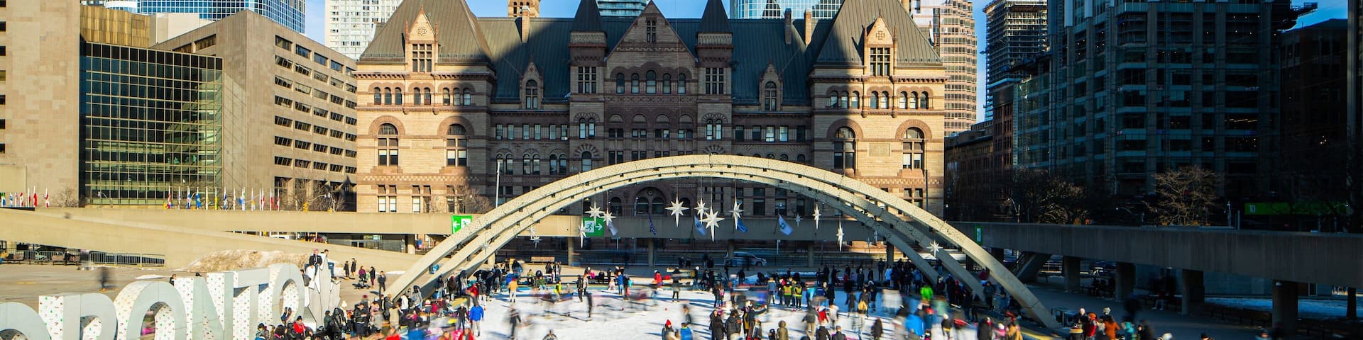 Nathan Phillips Square which includes a city and snow skiing as well as a large group of people