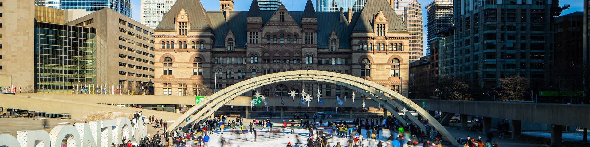 Nathan Phillips Square which includes a city and snow skiing as well as a large group of people