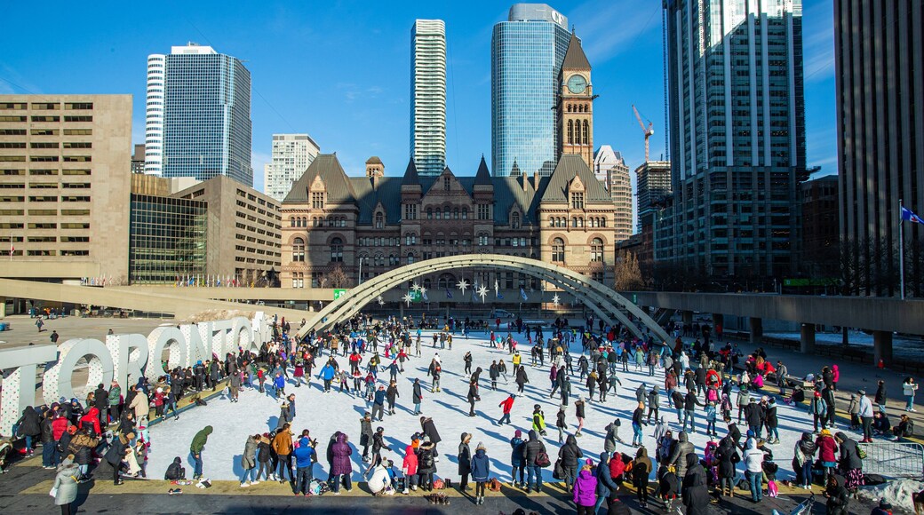 Nathan Phillips Square featuring a city and snow skiing as well as a large group of people