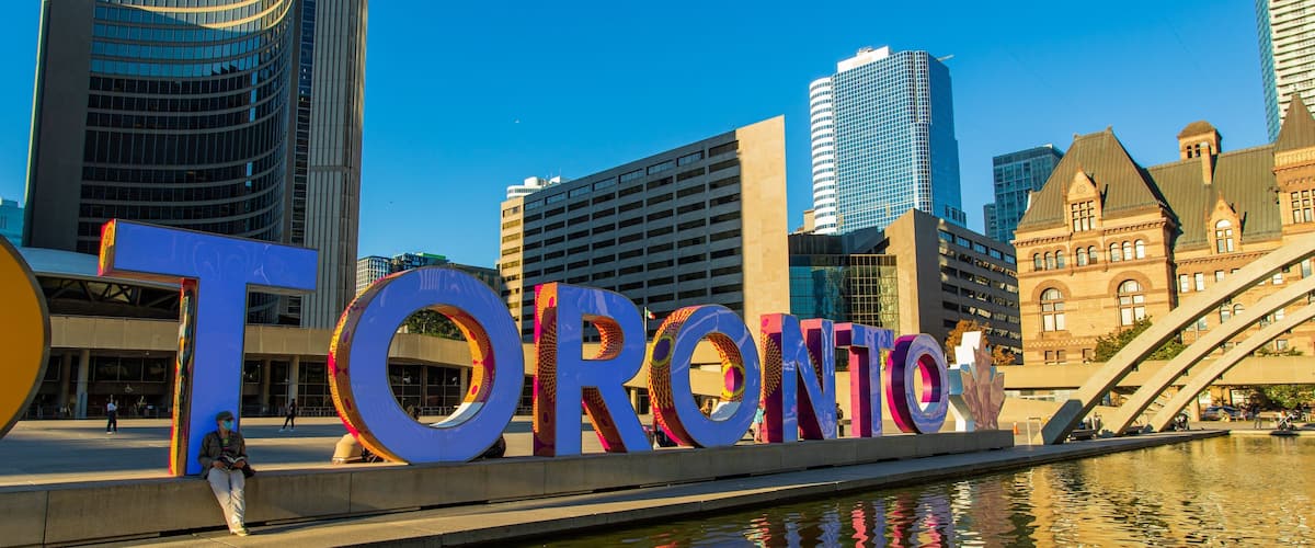 Nathan Phillips Square showing a pond, signage and a city