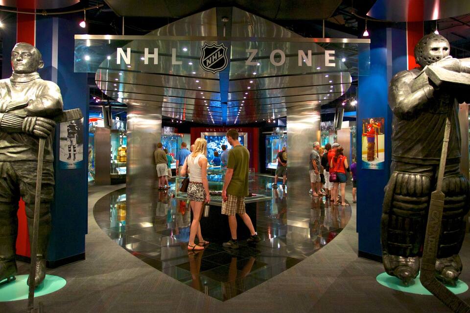 L'ingresso della NHL Zone con un grande logo NHL, due statue di giocatori di hockey su ghiaccio e persone che passeggiano all'interno.