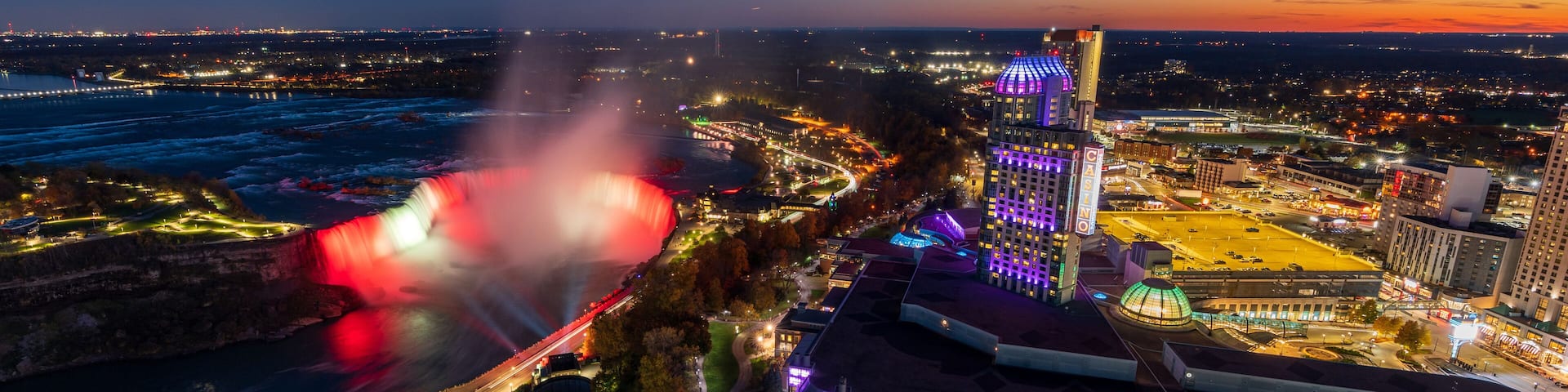 Aerial view of Horseshoe Falls in twilight time. Niagara Falls City downtown illumination. Stunning landscape at night.
