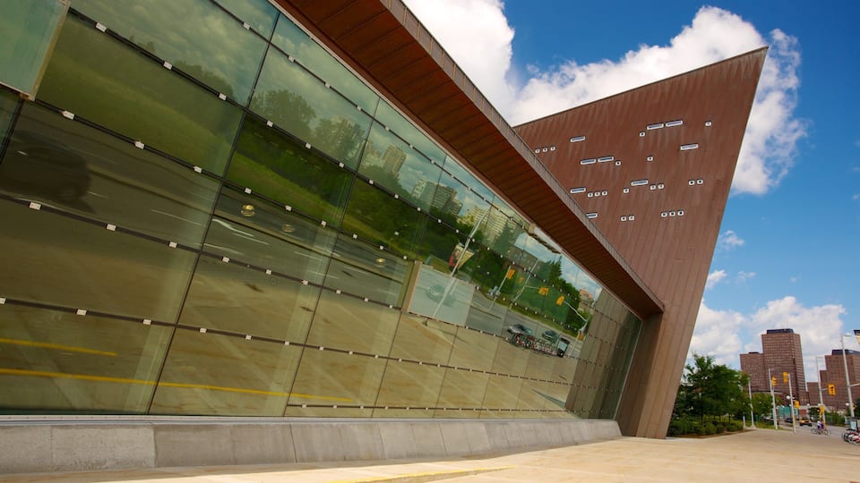 A modern building with a reflective glass facade and a triangular roof.