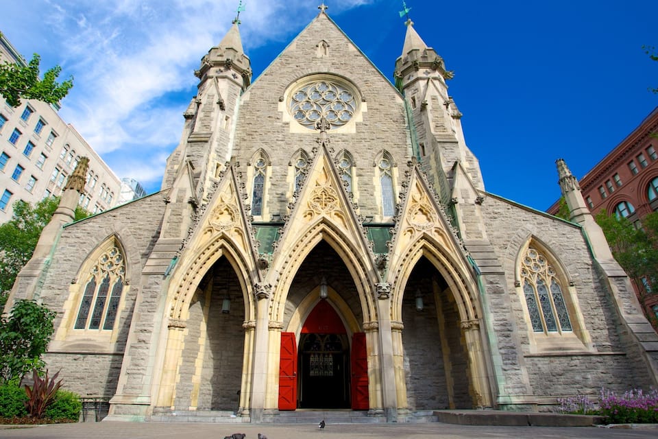 Una chiesa storica con architettura gotica, caratterizzata da archi a sesto acuto, un'ampia vetrata a rosone e una guglia.