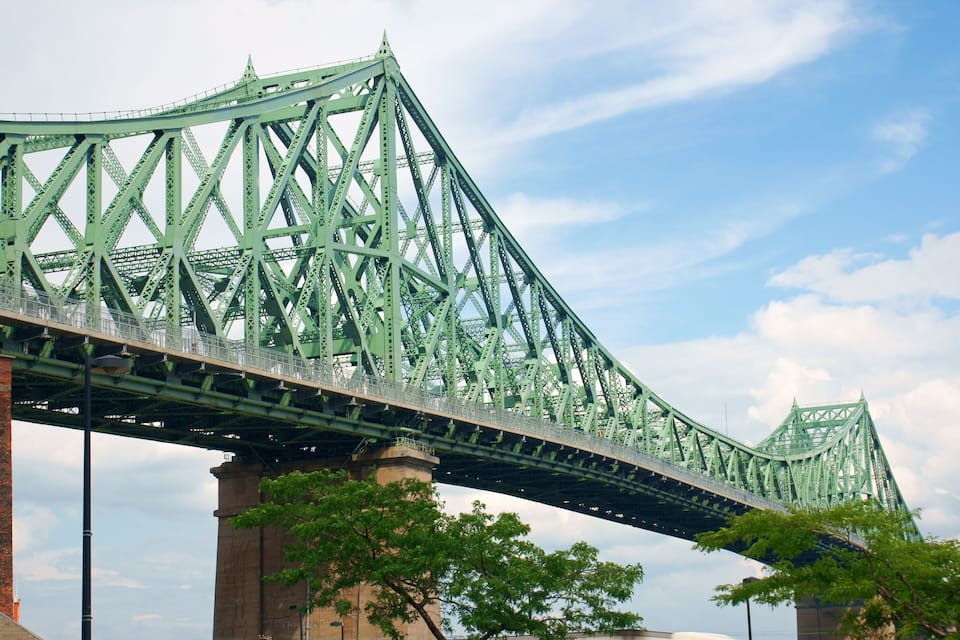 Un grand pont en acier vert doté d’une structure en treillis triangulaire.