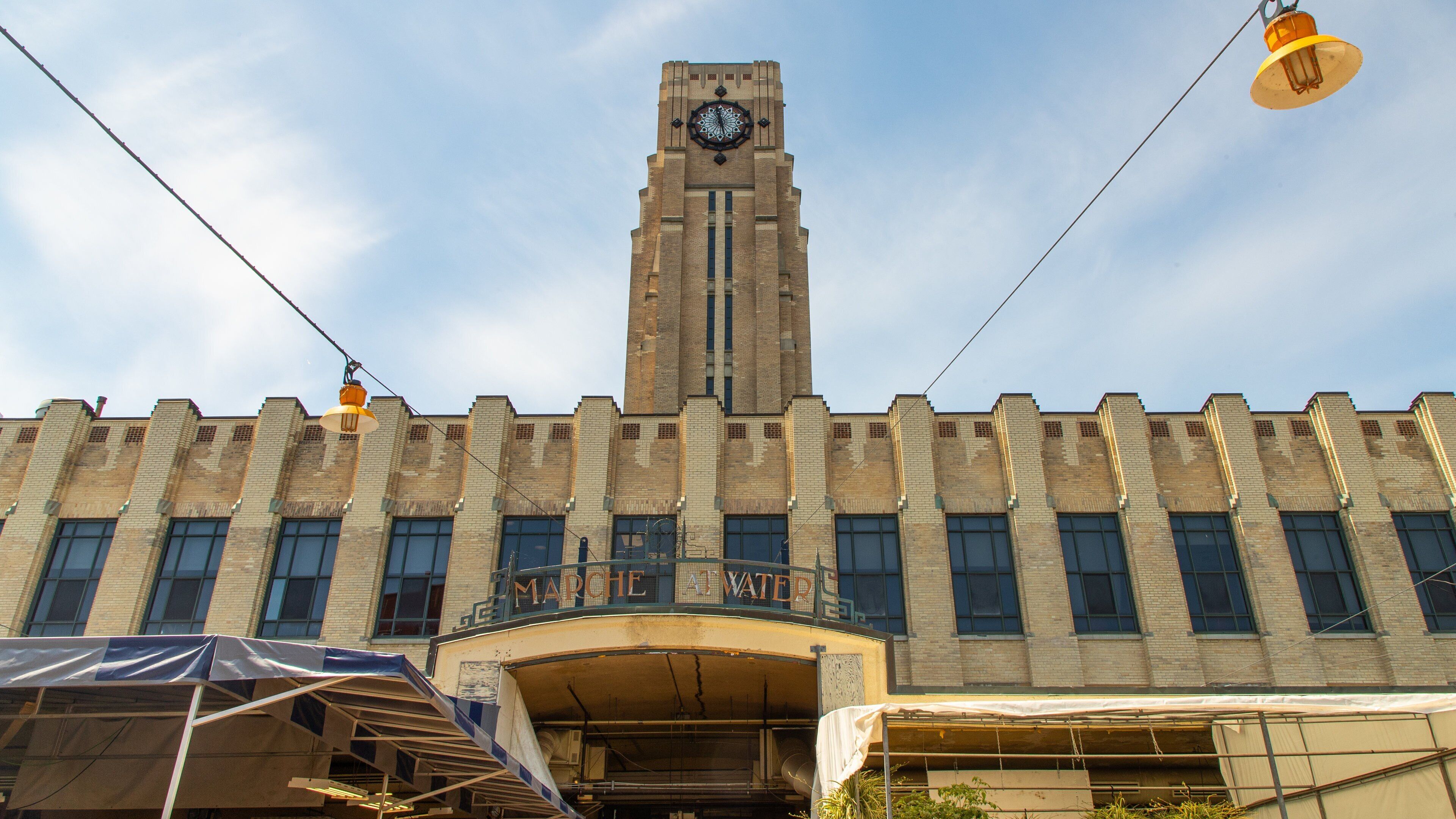 A large brick building with a clock tower, a balcony, and a sign that reads "CHEMICAL WAREHOUSE".