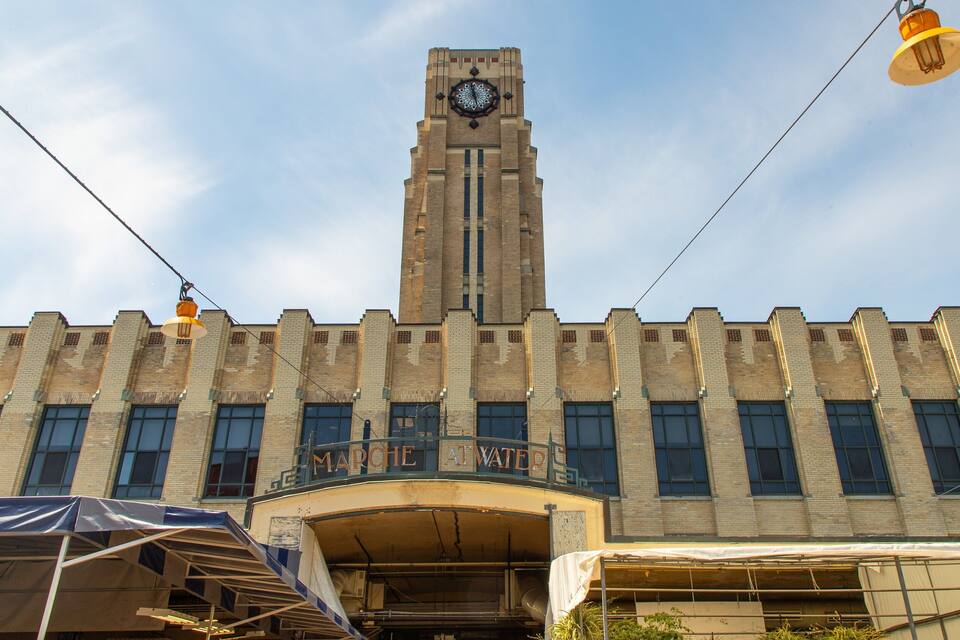 Un edificio grande de ladrillo con una torre del reloj, un balcón y un letrero que dice "CHEMICAL WAREHOUSE".