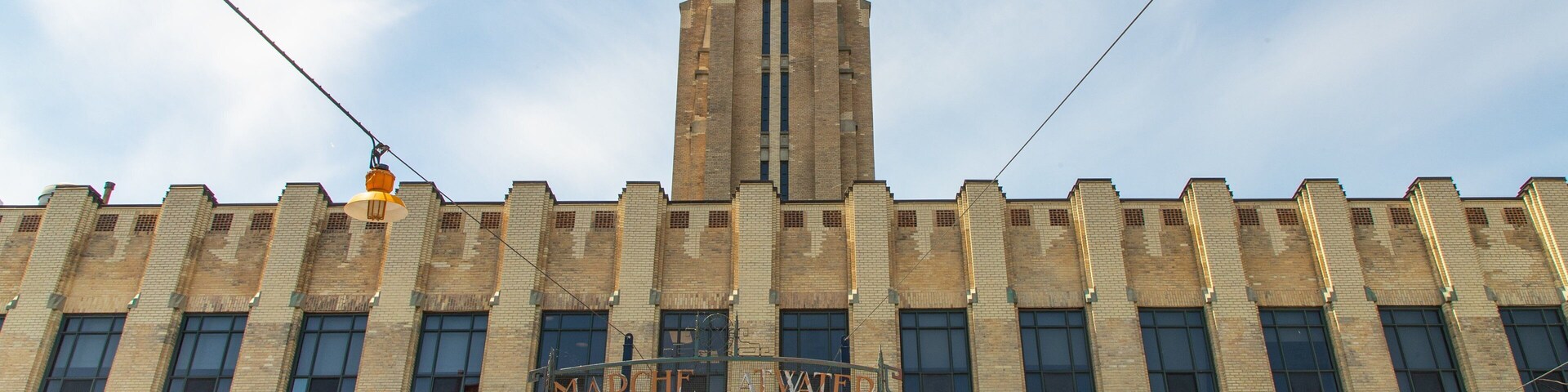 Un edificio grande de ladrillo con una torre del reloj, un balcón y un letrero que dice "CHEMICAL WAREHOUSE".