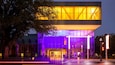 A modern building with illuminated windows and a sign for the Picasso Museum.