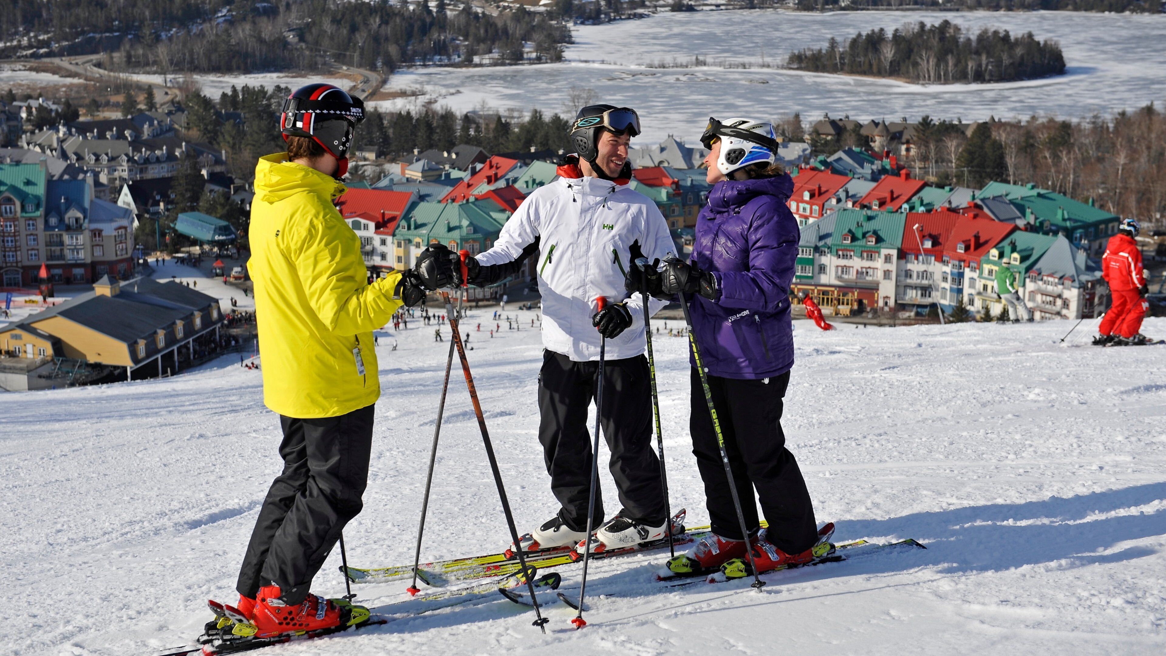 Mont-Tremblant Ski Resort showing snow and a small town or village as well as a small group of people