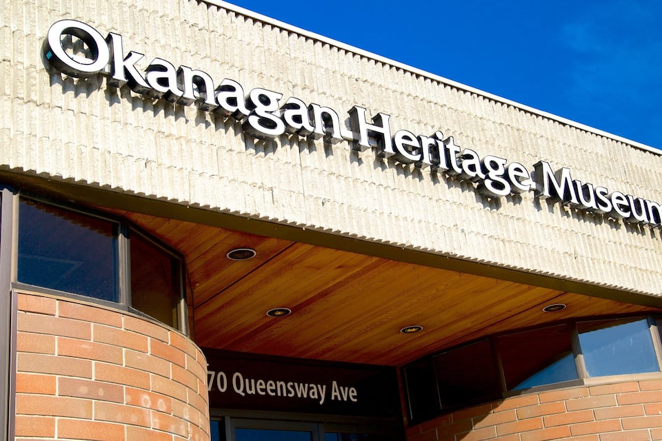 The exterior of the Okanagan Heritage Museum with a clear blue sky in the background.