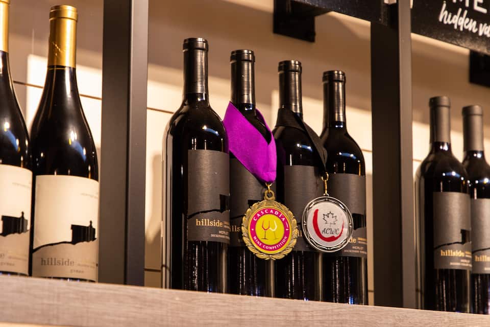 Une exposition de bouteilles de vin, chacune étant ornée d’une médaille.