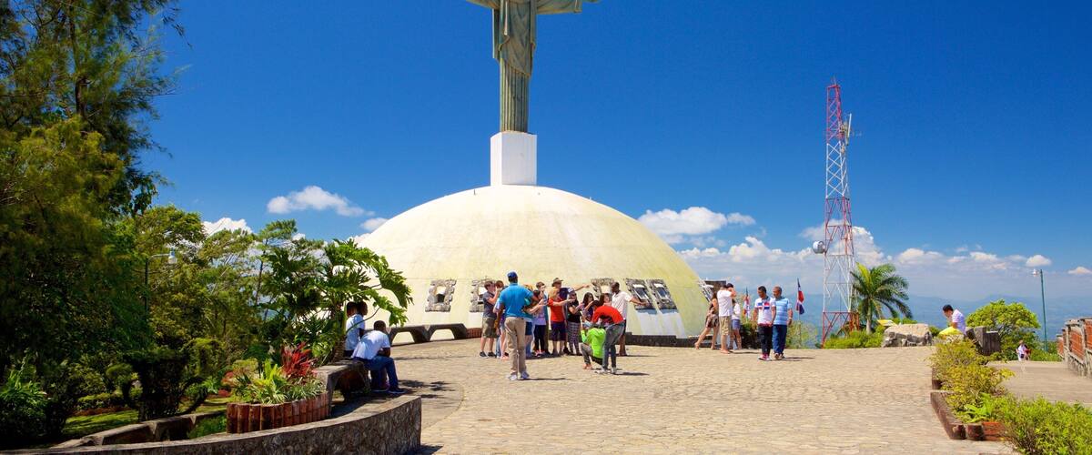 Pico Isabel de Torres mostrando una estatua o escultura y elementos religiosos y también un pequeño grupo de personas