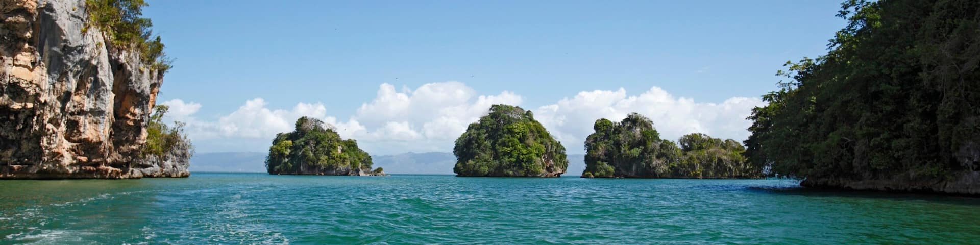 Parque Nacional Los Haitises ofreciendo costa rocosa, vistas generales de la costa y imágenes de una isla
