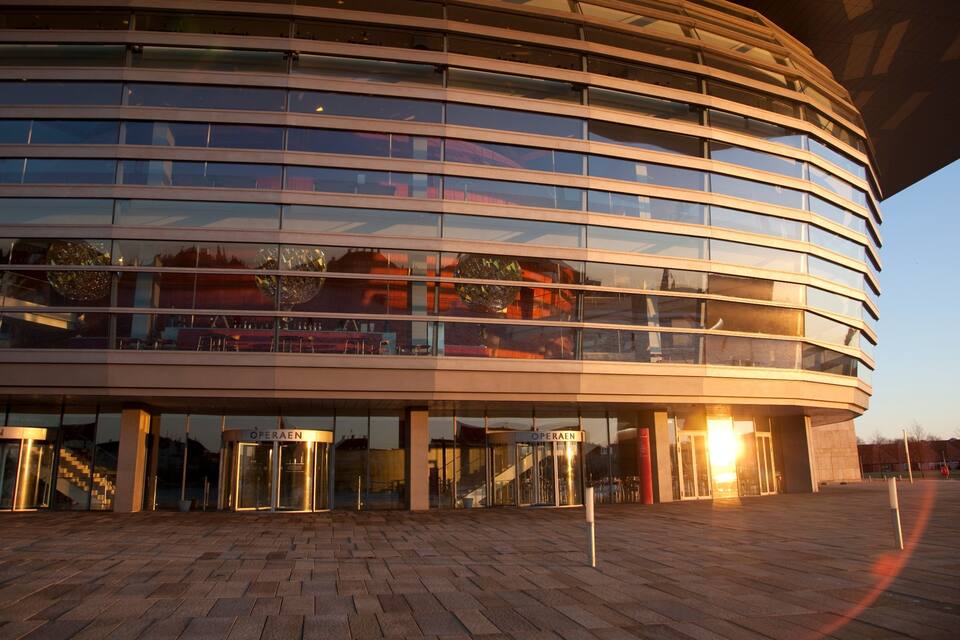 A modern building with a curved facade and multiple glass windows.