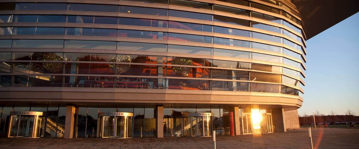 A modern building with a curved facade and multiple glass windows.