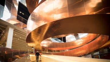 A modern architectural structure with curved metallic elements and a staircase.